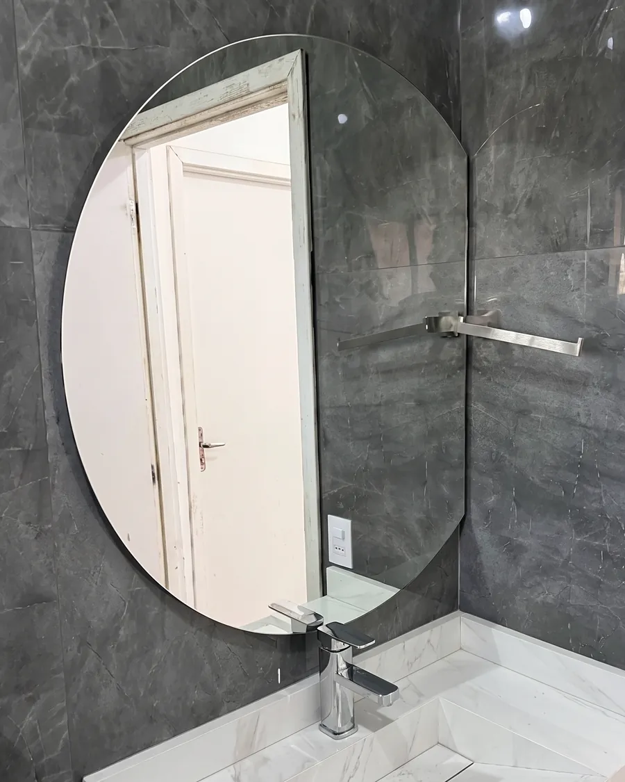 Espelho redondo lapidado, instalado sobre bancada de lavabo